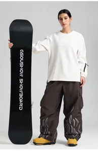Detail of loose fit brown ski pants featuring reflective flame pattern and high waist design