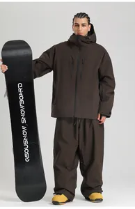 Waterproof dark brown ski jacket and pants set with functional zipper pockets on chest