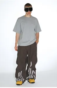 Detail shot of men's loose ski pants with white flame prints and reflective waist design