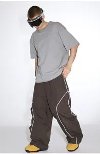 Detail of loose-fit waterproof ski pants with reflective stripes and contrast piping