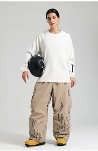 Detail view of khaki cargo ski pants and white sweatshirt with waist protection for skiing