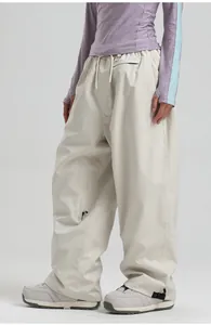 Detail view of beige ski pants featuring drawstring waist and cargo zip pocket