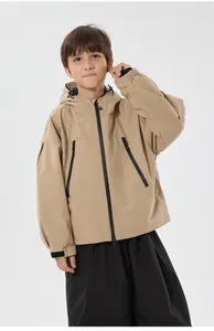 Detail of khaki kids ski jacket featuring waterproof fabric and black zipper pockets