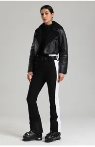 Détail d'une combinaison de ski ajustée avec veste noire et bottes de ski ATOMIC pro