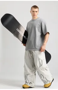 Detail of baggy ski pants featuring black flame print and functional cargo side pockets