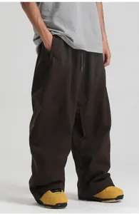 Detailed view of dark brown loose ski pants featuring an elastic drawstring waist and side pockets