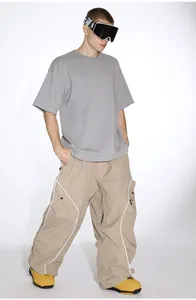 Detail of khaki outdoor ski pants featuring large cargo pockets and white contrast stitching
