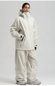 Détail d'une tenue de ski blanc cassé avec veste à capuche et pantalon assorti