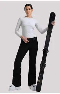 Pantaloni da sci professionali neri da donna con maglia termica e sci Atomic