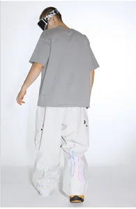 Detail view of the colorful reflective flame print on cream baggy cargo pants