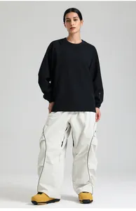 Close-up of stylish oversized black sweatshirt and beige utility pants for skiing