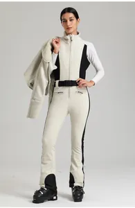 Combinaison de ski ajustée avec panneaux contrastés, ceinture et détails de la veste