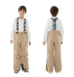 Detail of khaki kids' ski bib pants with adjustable straps and green waterproof zippers