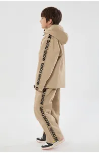 Side view of children's khaki ski suit featuring functional windproof fabric and branding