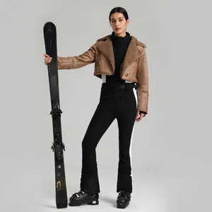 Ensemble de ski femme avec veste marron, combinaison stretch noire et skis Atomic