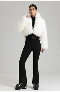 Détail de la veste de ski femme en fausse fourrure blanche avec pantalon noir ajusté