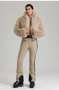 Détail d'une combinaison de ski beige pour femme avec col en fausse fourrure et rayures