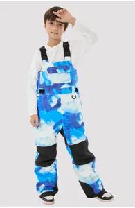 Detail of kids ski bib pants with blue ink print, adjustable straps and reinforced knees
