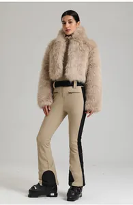 Détail de la combinaison de ski beige ajustée avec ceinture et veste en fausse fourrure