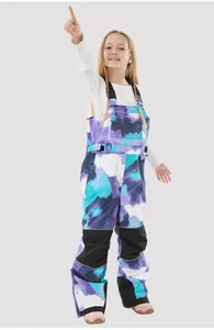 Detail of color-block kids ski bib pants with adjustable straps and reinforced cuffs