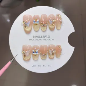 Press-on nails featuring golden lion dance motifs and 3D butterfly accents