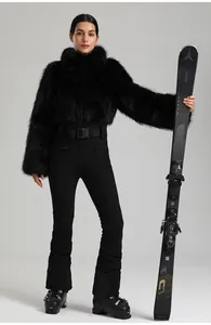 Détail d'une veste de ski en fausse fourrure noire avec ceinture GSO et pantalon ajusté