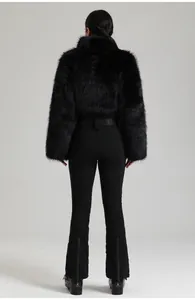 Détail de la veste de ski en fausse fourrure noire et pantalon slim avec zips