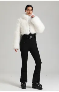Détail de la veste en fausse fourrure blanche et du pantalon de ski noir taille haute