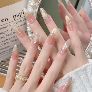 Pink gradient almond press-on nails with golden glitter, pearls and 3D butterfly charms