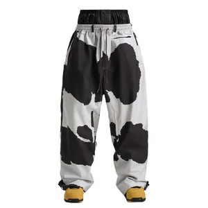 Waterproof cow print ski pants featuring a double-layered high waist and cargo pockets