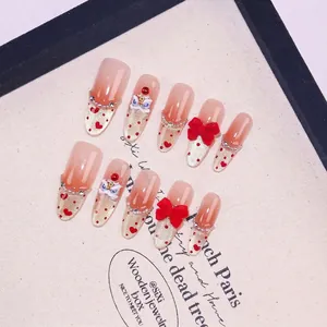 Handmade press-on nails with red lion dance decor, bows, and pearls on pink gradient base