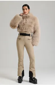 Détail d'une combinaison de ski beige style fourrure avec ceinture SNOW et pantalon ajusté