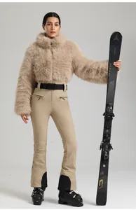 Vue détaillée de la veste de ski en fourrure beige et du pantalon de ski ajusté assorti