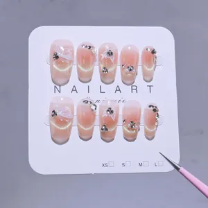 Handmade cat eye press-on nails with blush gradient and 3D butterfly rhinestones