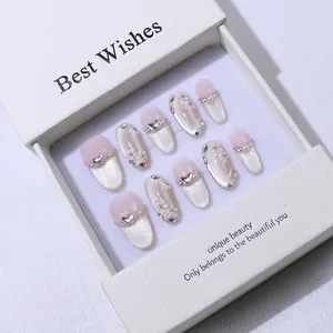 Détail d'ongles faits main œil de chat rose avec fleurs 3D blanches et perles