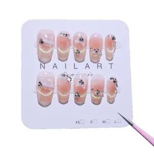 Handmade press-on nails with pink cat-eye effect and silver butterfly rhinestones