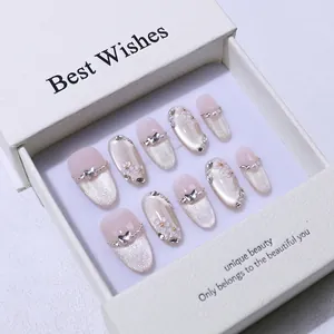 Détails macro de faux ongles cat-eye faits main avec nœuds 3D et fleurs en coffret