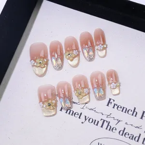 Handmade gradient pink press-on nails with 3D resin flowers and shimmering gold cat-eye detail