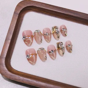 Handmade almond press-on nails in nude cat-eye finish with luxury crystals and pearls
