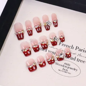 Handmade cherry red press-on nails with French blush design and sparkling crystals