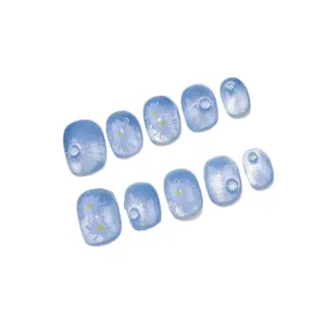 Cat eye blue press-on nails with white daisy flowers and elegant pearl decorations