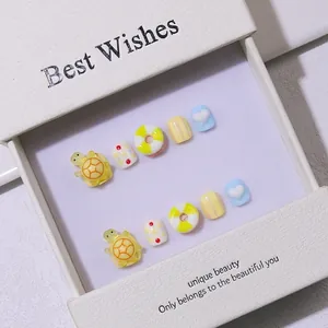 Cute cartoon press-on nails for kids with 3D yellow turtles and colorful DIY heart charms
