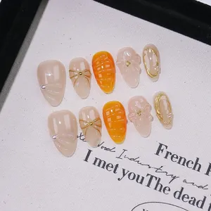 Handmade almond press-on nails with 3D floral carving, pearls and gold bows