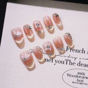 Unghie finte fatte a mano a mandorla nude cat eye con motivi a farfalla e strass scintillanti