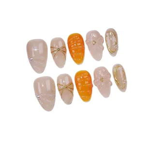 Handmade almond press-on nails with 3D floral relief, orange accents, and pearls