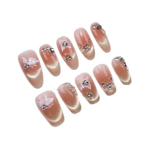 Unghie finte fatte a mano nude con sfumatura glitter occhio di gatto e strass farfalla