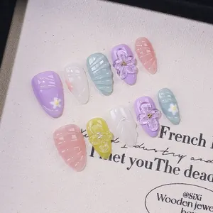 Handmade almond press-on nails with 3D floral carvings and pastel macaron colors
