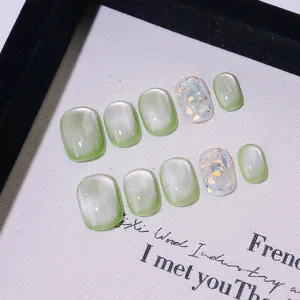Faux ongles faits main œil de chat vert clair avec des accents de paillettes