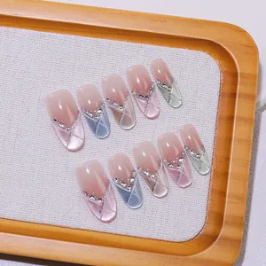 Detail of handmade press-on nails with rainbow cat eye effect and rhinestone accents