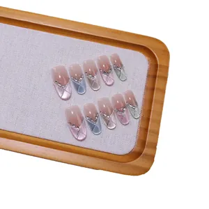 Handmade cat-eye press-on nails with nude pink gradient, silver lines, and glitter accents
